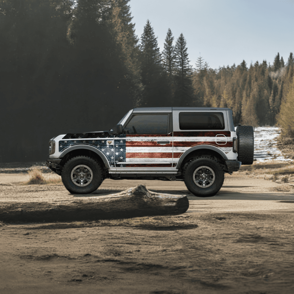 Ford Bronco 2D with MEK removable trail armor featuring an American flag design, parked in a forest trail setting.